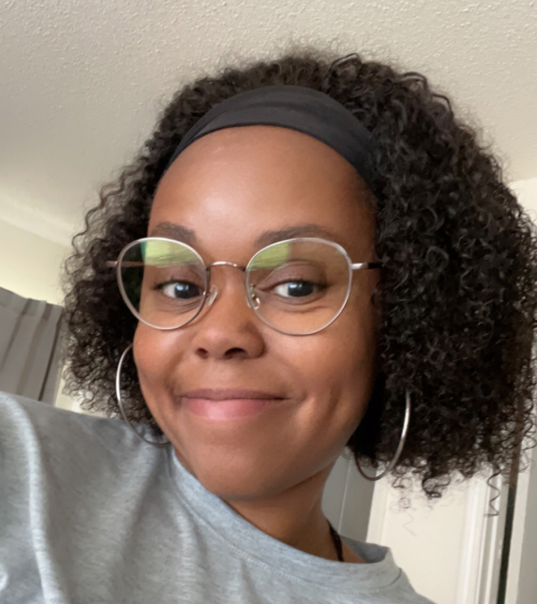 Headshot Of Woman With Curly Hair Wearing Glasses, Black Headband