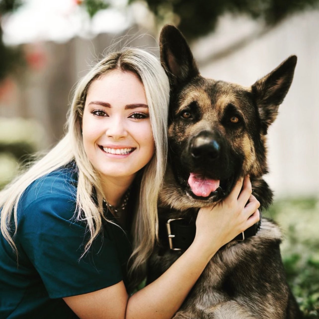 Blond Woman In Teal T-Shirt Snuggling A Large German Shepherd